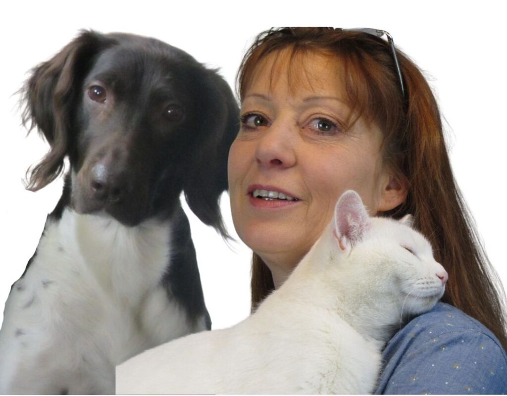 Frau mit Katze auf dem Arm und ein Hund schaut ins Bild